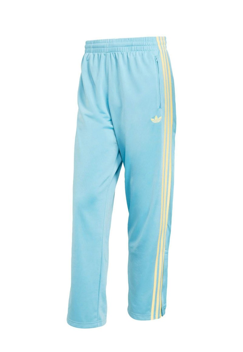 Pantaloni da tuta azzurri con vita elasticizzata, strisce laterali gialle, tasca con cerniera e piccolo logo trefoil sul lato.