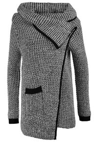 Cárdigan de punto grueso en blanco y negro, con un gran cuello vuelto, un diseño asimétrico y un bolsillo de parche en la parte delantera. Textura suave.