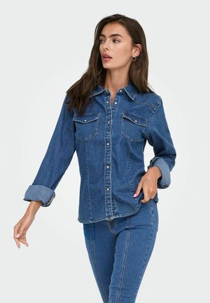Denim overhemd in medium blauw met lange mouwen, knoopsluiting aan de voorkant, twee borstzakken en een standaard kraag. Heeft opgerolde mouwen en een getailleerde pasvorm.
