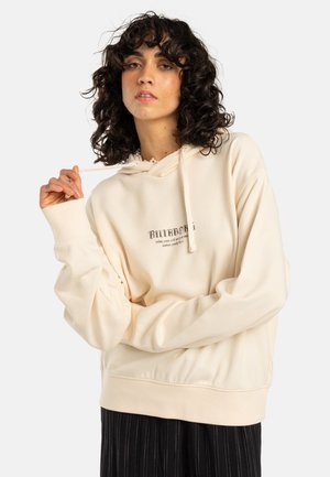 Cream-colored hoodie with a drawstring, relaxed fit, and ribbed cuffs. Features a printed logo design on the front. Soft texture.