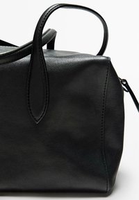 Borsa a mano in pelle nera con forma strutturata, due manici e cuciture visibili lungo i bordi. Texture liscia senza motivi o dettagli.
