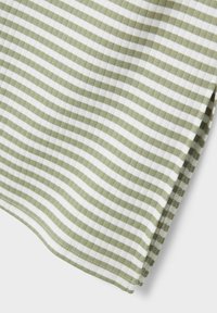 Tissu rayé vert et blanc avec une texture côtelée, présentant des lignes horizontales et un bord ourlé.