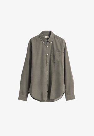 Camisa de manga larga en tejido verde oliva, con cuello abotonado, bolsillo en el pecho y dobladillo curvado. Textura suave y corte ajustado.