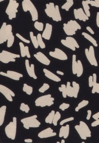 Motif abstrait de formes beige irrégulières dispersées sur un fond noir, ressemblant à des coups de pinceau ou des taches.