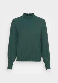 Mörkgrön långärmad topp med hög volangkrage och elastiska ärmslut. Tyget har en texturerad yta och en elastisk nederkant.