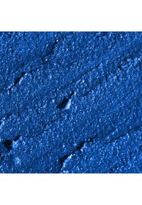 Livlig blå mineralpudder med en teksturert overflate. Fine, glitrende partikler skaper et rikt utseende mot en matt bakgrunn.