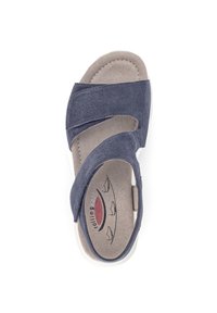 Marineblauwe suède sandaal met overlappende banden, zachte grijze voering en gevoerde binnenzool. Witte rubberen buitenzool met subtiele ontwerpelementen.