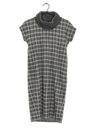 Robe sans manches à carreaux gris avec un large col roulé tricoté, suspendue à un cintre noir.