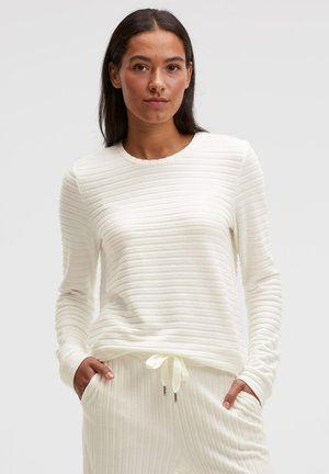 White long-sleeve top with a textured ribbed design, round neckline, and flexible fit, paired with matching drawstring pants.