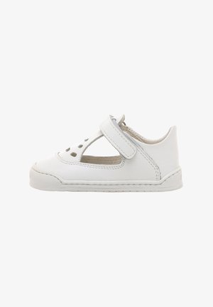 Zapato infantil de cuero blanco con detalles perforados, tira en forma de T y cierre de Velcro. Presenta una suela cosida y un diseño de punta redondeada.