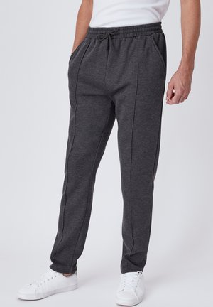 Donkergrijze joggingsbroek van zacht materiaal, met een elastische tailleband, trekkoordsluiting, zijzakken en contrasterende zijnaad.