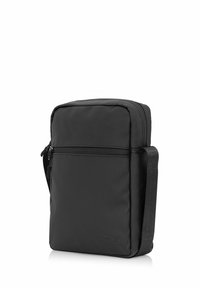 Czarna syntetyczna torba na ramię z zamknięciem głównym na zamek błyskawiczny oraz przednią kieszenią. Gładka tekstura i prostokątny kształt, z regulowanym paskiem.