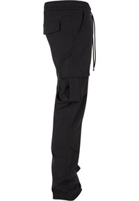 Černé nákladní kalhoty s volným střihem, vybavené bočními kapsami, elastickým pasem a stahovací šňůrkou. Tkanina působí lehce.