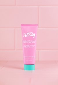 Rosa tub med Merci Handy Detoxifying Mask och turkos lock. Innehåller vit text som beskriver ingredienser och fördelar. 75 ml storlek.
