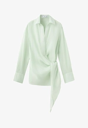Blusa de manga larga verde claro con cuello, escote en V profundo y detalle de lazo de tela en el lado derecho de la cintura.