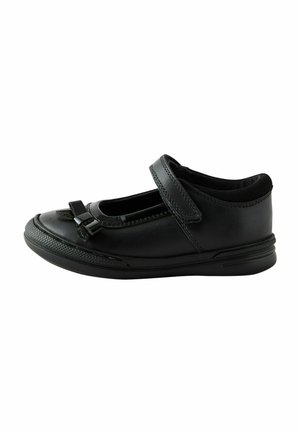 Chaussure en cuir noir avec un bout arrondi, une sangle velcro et un accent en nœud décoratif. Présente un côté texturé et un design de semelle intérieure rembourrée.