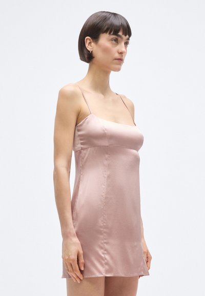 Satino suknelė spalvos rausvų atspalvių, su plonomis petnešėlėmis, kvadratine iškirpte ir lygiu paviršiumi. Šiek tiek aptempianti, su tiesiu apdaila.