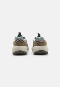Vista posteriore di scarpe sportive con tomaia in mesh di colore azzurro chiaro e accenti in suede marrone, suola beige testurizzata e linguetta.