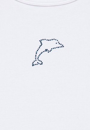 Forme de dauphin formée de petites perles foncées sur un fond en tissu blanc côtelé.