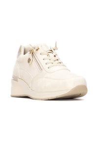Zapatilla deportiva beige con parte superior de ante, cremallera acentuada, suela acolchada y detalles texturizados en la punta. Cuenta con cierre de cordones para un ajuste adecuado.