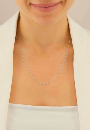 Collana in argento con un design sottile e delicato, caratterizzata da una texture liscia e da un leggero luccichio, che riposa su un collo nudo.