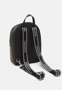 Black faux leather backpack with rounded shape, zip closure, and adjustable straps featuring prominent "VALENTINO" logo in white.