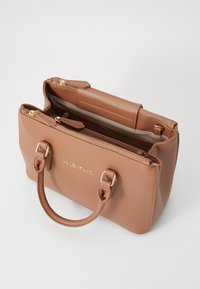 Hnědá kožená kabelka se zlatým kováním, zipovým uzávěrem a dvojitými uchy. Disponuje texturovaným povrchem a viditelným logem na přední straně.