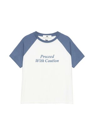 T-shirt raglan à manches courtes avec manches bleues et corps blanc, texte "Proceed With Caution" imprimé sur le devant en lettres bleues.