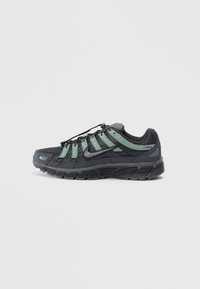 Nike P-6000 sneakers feature a black mesh upper with green accents, textured surface, rounded toe, and a sturdy rubber outsole.