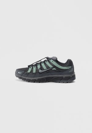 Nike P-6000 sneakers feature a black mesh upper with green accents, textured surface, rounded toe, and a sturdy rubber outsole.