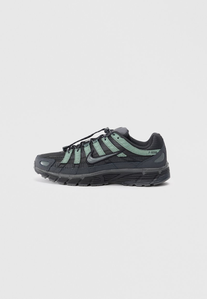 Nike P-6000 sneakers feature a black mesh upper with green accents, textured surface, rounded toe, and a sturdy rubber outsole.