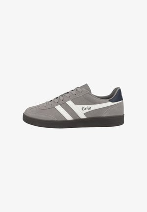 Zapatillas de ante gris con rayas diagonales blancas y logo. Suela de goma negra, diseño de cordones, ligera amortiguación y puntera redonda.