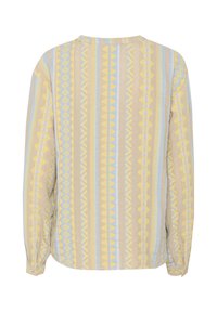 Chemise à manches longues en beige clair avec des motifs géométriques bleus et jaunes. Dotée d'un col rond et d'une coupe décontractée. Tissu texturé.