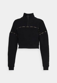 Sudadera corta negra con cuello alto, cremallera de cuarto y mangas largas. Presenta bandas de logotipo doradas en el pecho y las mangas. Material suave.