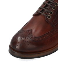 Braune Leder-Brogue-Schuhe mit runder Spitze, dekorativen Perforationen und strukturiertem Obermaterial sowie einer kontrastierenden holzähnlichen Sohle.