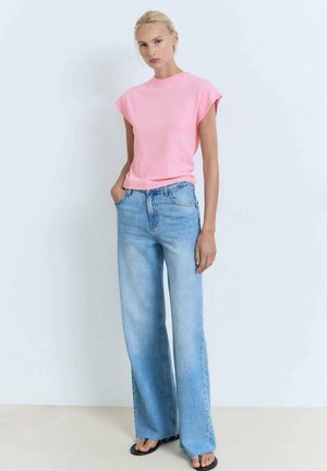 Tricou roz cu mânecă scurtă, asortat cu blugi ușori, cu talie înaltă și pantaloni largi, având o croială lejeră și o textură de țesătură moale.
