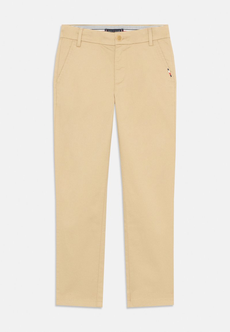 Beige Chinos aus Baumwolle mit geradem Schnitt. Sie verfügen über Fronttaschen, einen Knopfverschluss und dezente Logo-Details an der Seite.