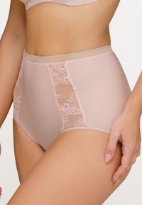Hochgeschnittene Unterwäsche aus zartrosa Stoff mit Spitzenpaneelen an den Seiten. Glatte Textur mit einem bequemen elastischen Bund.