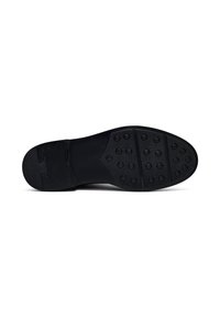 Sole di scarpa nera con pattern di presa in gomma circolari e area del tallone liscia, mostrata su uno sfondo bianco.