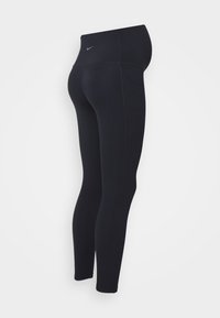 Leggings de sport noirs avec une taille haute, texture lisse, poche latérale et petit logo bleu sur la ceinture.
