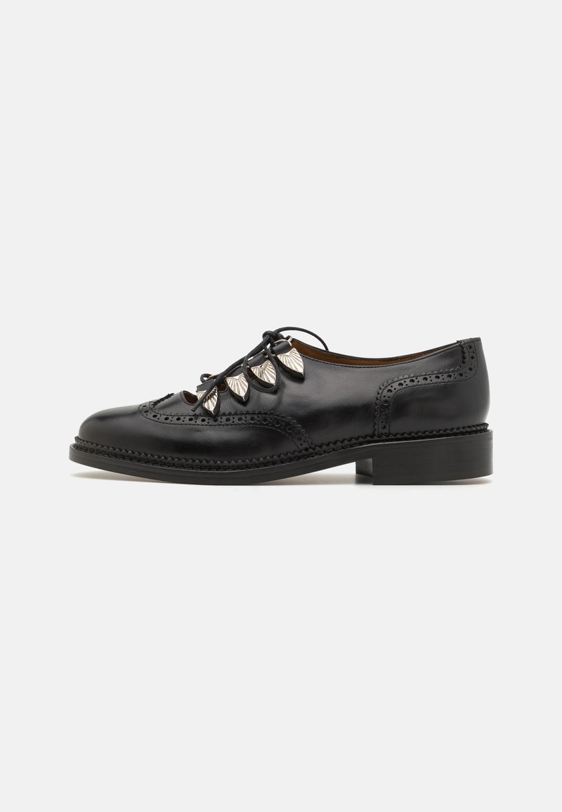Mustad mustad nahast neidude kingad, millel on dekoratiivsed leheaktsendid, brogue-detailid, ümmargune varvas ja madal plokkkonts koos tekstureeritud tallaga.