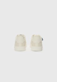Kreemi värvi sneakerid sileda tekstuuriga, millel on minimalistlik disain, kontrastsed aktsendid ja kummist tald haardeks.