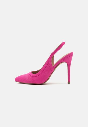 Lyst pink ruskind højhælet slingback sko med spids tå og tynd stilet hæl mod en ensfarvet baggrund.