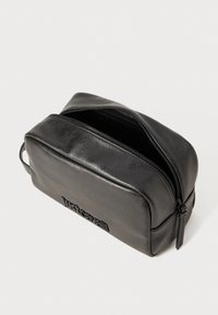 Fekete bőr toilett táska téglalap alakú, sima felülettel, felső cipzárral és a fronton dombornyomott logóval.