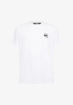 Bela bomba majica s kratkimi rokavi, okrogle izreza in majhnim črnim grafičnim logotipom na levi prsni strani. Mehka tekstura in sproščen kroj.