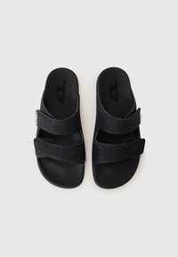 Sötét farmer slip-on szandál két anyagból készült pánttal és fekete textúrájú talppal. Ezüst csat részlettel ellátva a beállításhoz.