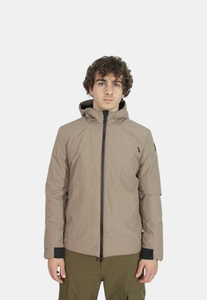 Giacca isolante color sabbia con cappuccio, chiusura frontale a zip, polsini elasticizzati e dettagli neri. Il tessuto appare liscio con cuciture minime.
