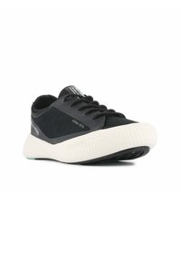 Czarne buty sportowe z teksturowaną białą podeszwą, z sznurowanym wzorem i zaokrąglonym noskiem. Szczegóły obejmują logo na języku i boku.