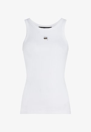 Maiou alb cu nervuri, fără mâneci, cu o mică față brodată, purtând ochelari de soare și un batic alb, centrată sub decolteu.