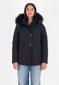 Zwarte geïsoleerde jas met een capuchon met bontkraag, knoopsluiting en twee zijzakken. De stof lijkt glad en duurzaam.